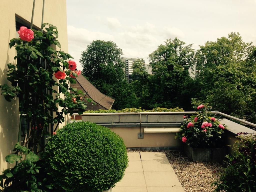 un jardín con rosas y flores en un balcón en AVLiving City FLAT Basel with Roof Garden, en Basilea