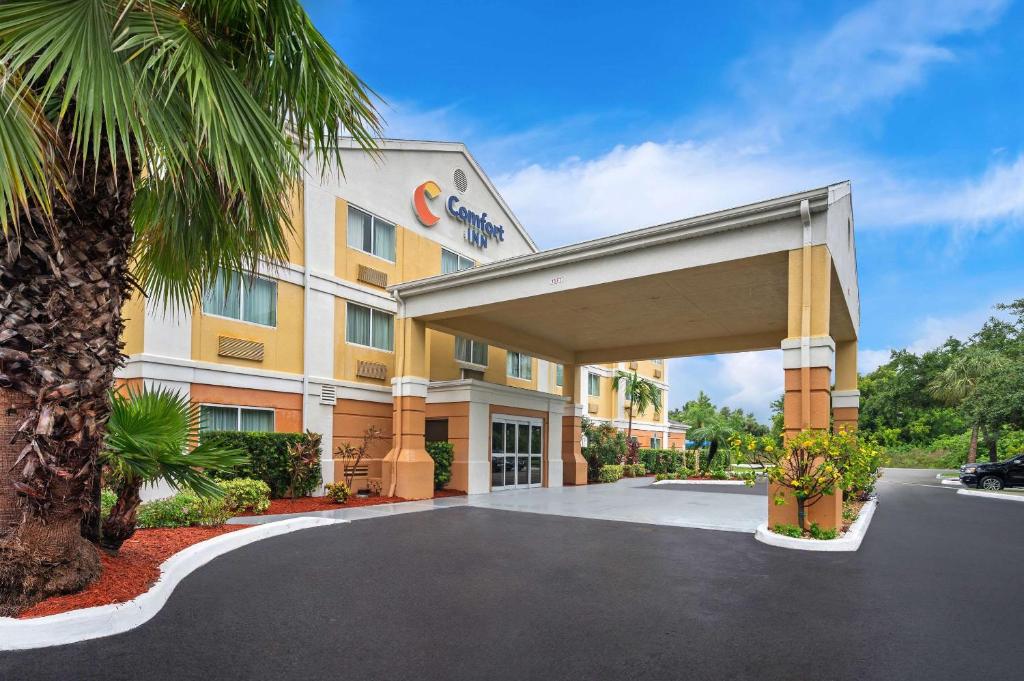 a hotel with a palm tree in front of it at Comfort Inn Fort Myers Northeast in Fort Myers