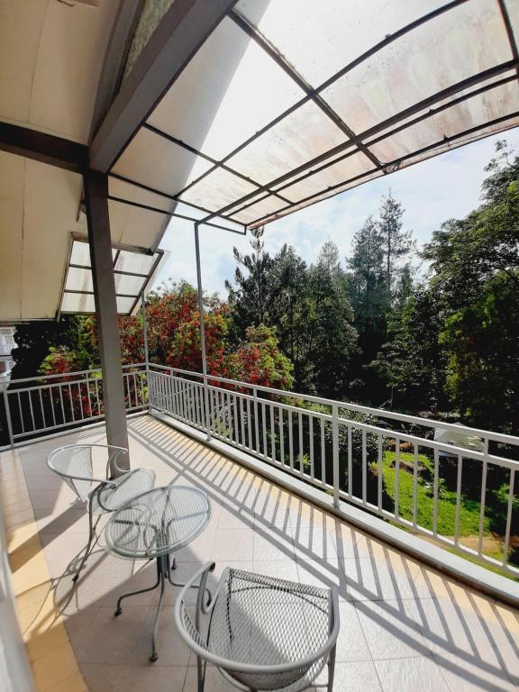 eine Terrasse mit Tischen und Stühlen auf einem Balkon in der Unterkunft Vila kota bunga in Cikundul