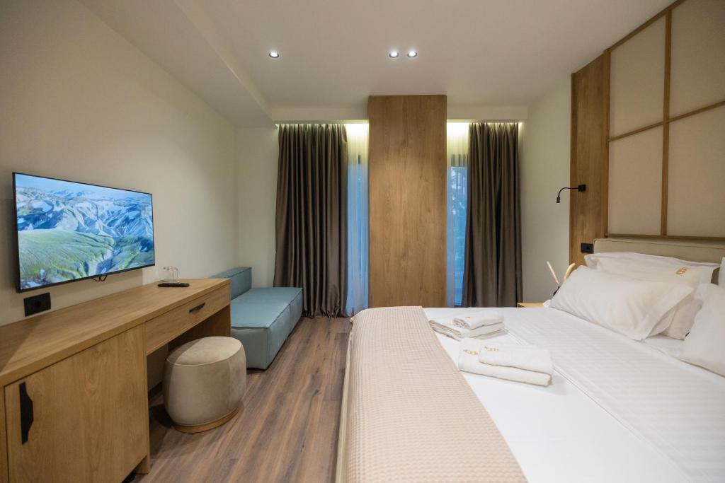 a hotel room with a bed and a flat screen tv at Beliz Boutique Hotel in Vlorë
