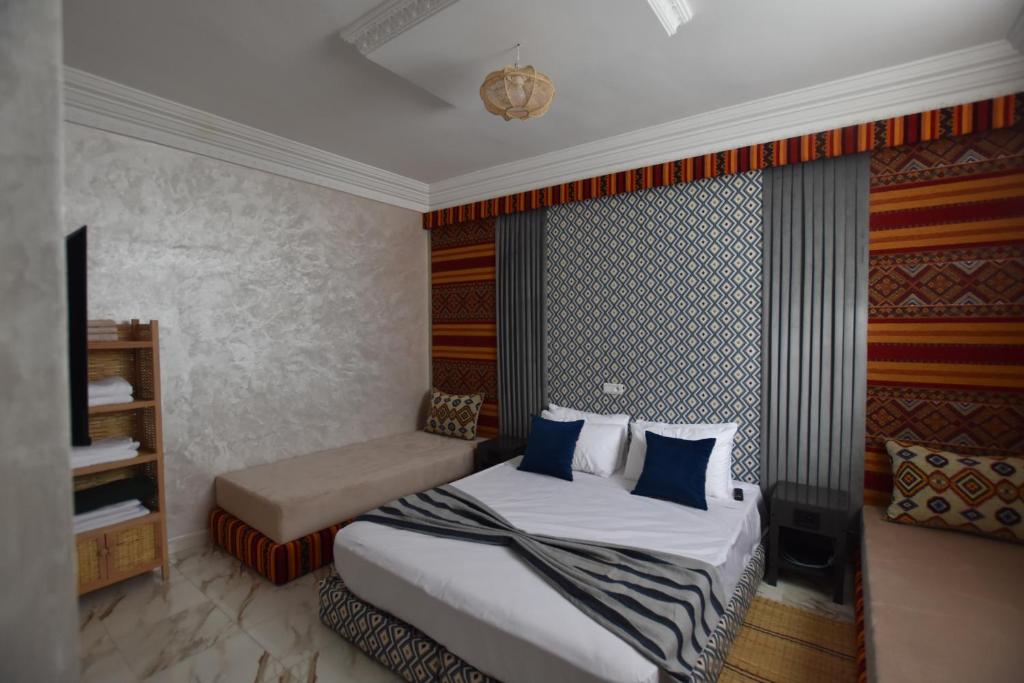 a hotel room with a bed and a couch at Maison Nomedia in Essaouira