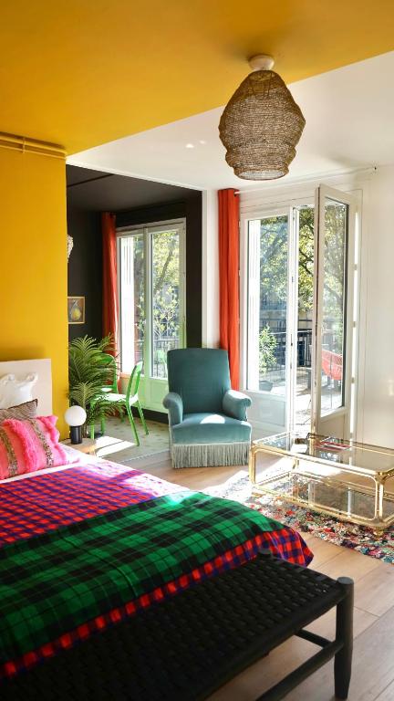 une chambre avec un lit, une chaise et des fenêtres dans l'établissement Saint-Michel, au Havre