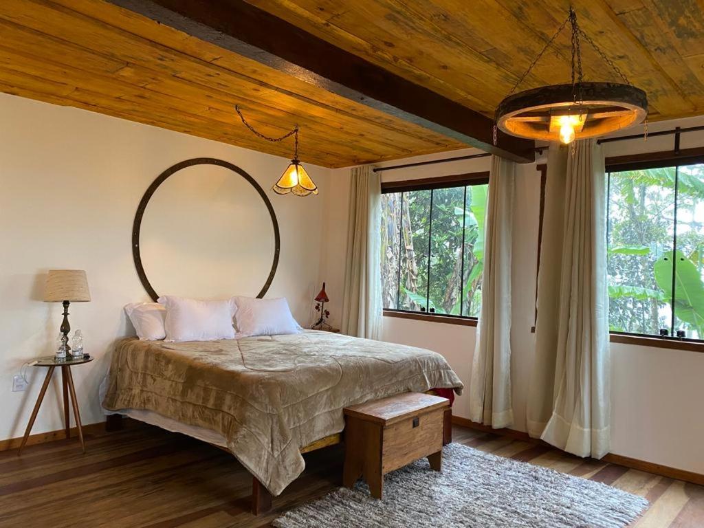 ラブラス・ノーヴァスにあるChalé da Mata Lavras Novasのベッドルーム(大型ベッド1台、大きな鏡付)