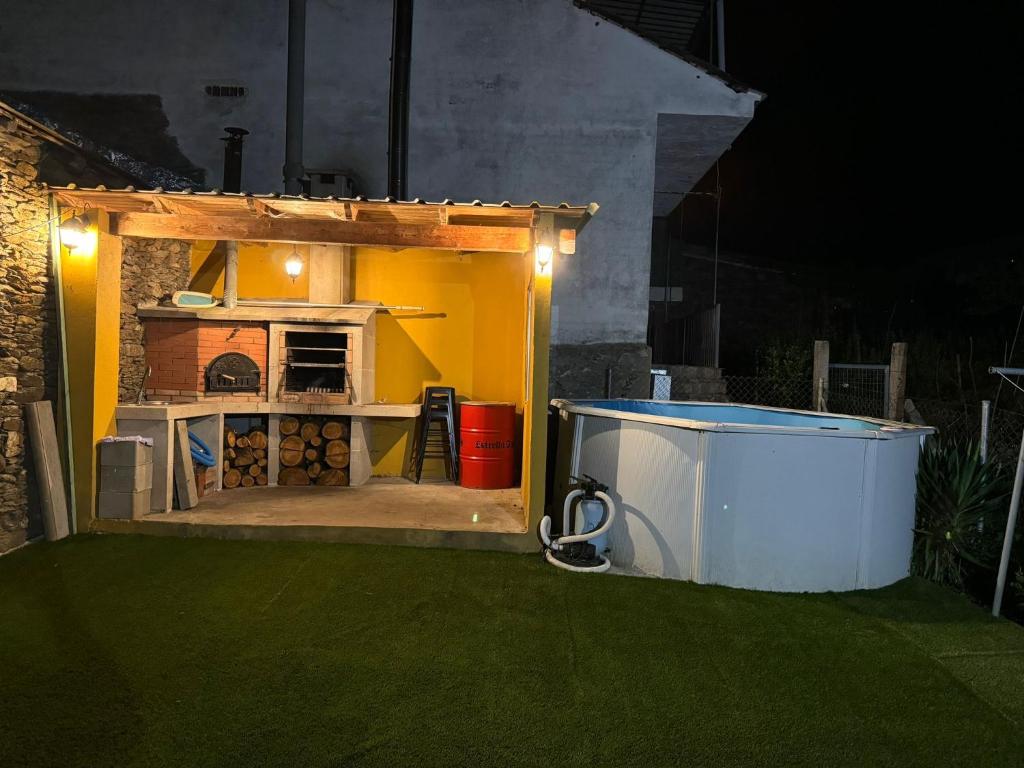 a backyard with an outdoor kitchen and a grill at casa carmiña in Ourense