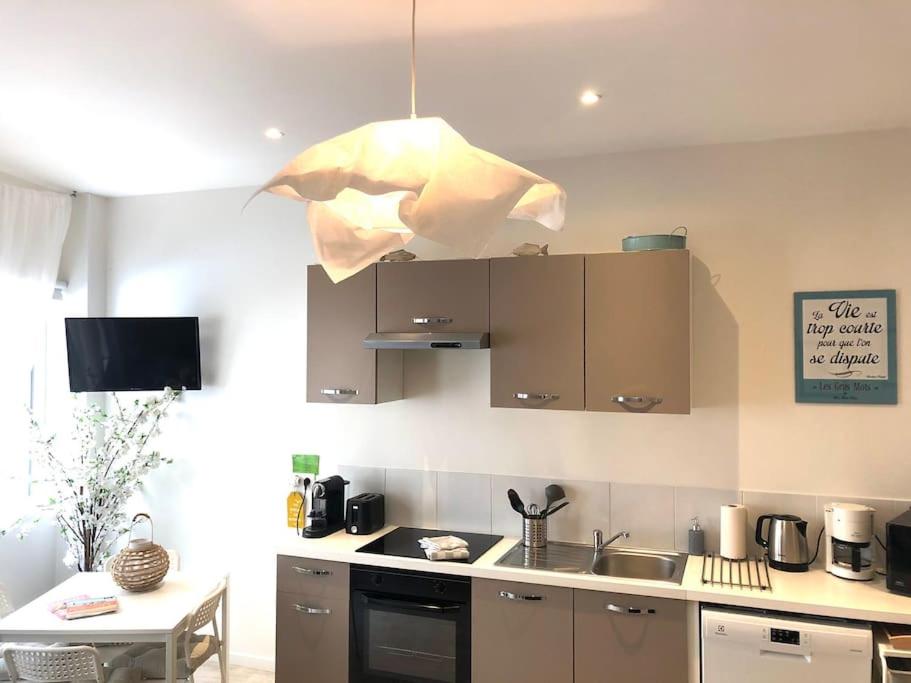 une cuisine avec un évier et une cuisine avec une lumière dans l'établissement Appartement cosy à Trouville, à Trouville-sur-Mer