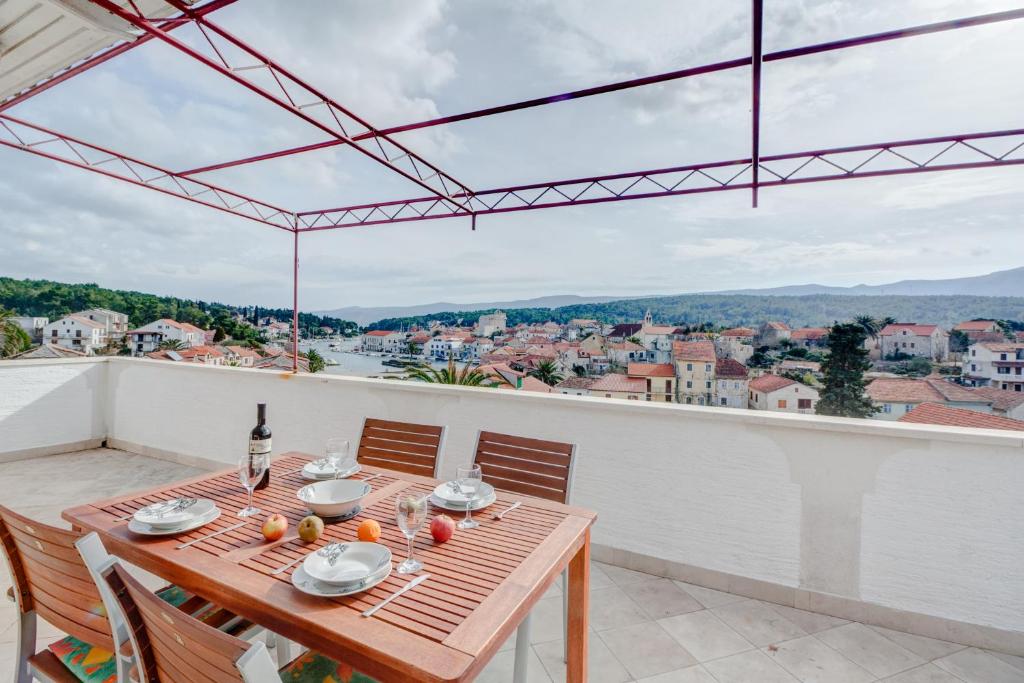 a table on a balcony with a view of a city at Apartment with beautiful view and big terrace in Vrboska