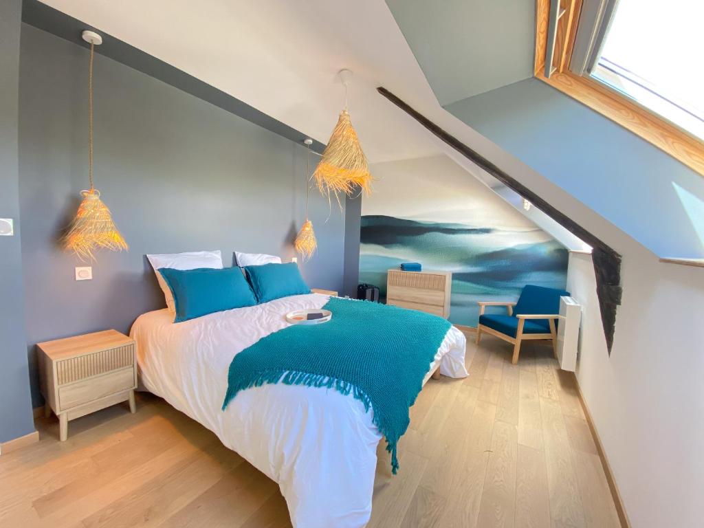 une chambre avec un lit avec une couverture bleue et blanche dans l'établissement Maison Amarée, à Pleudihen-sur-Rance