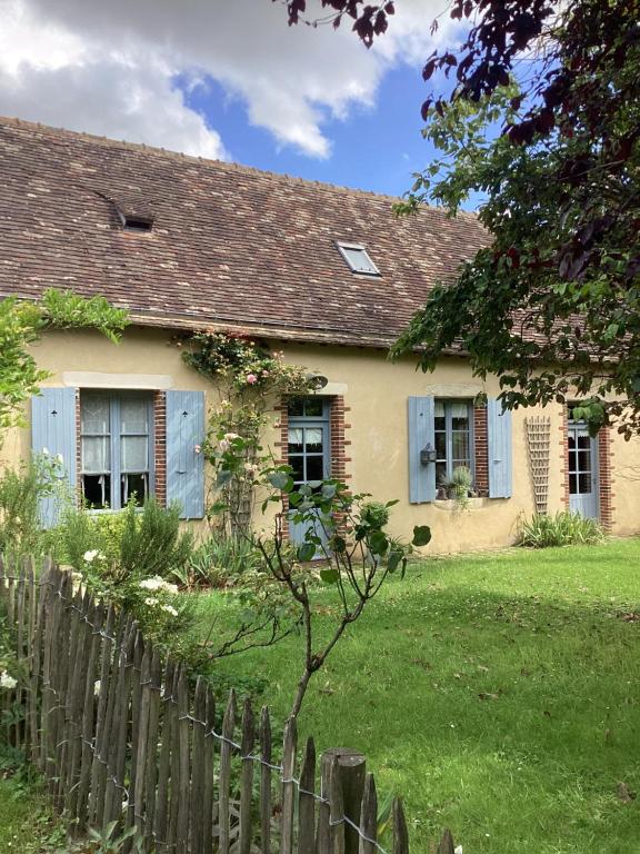 une vieille maison avec une clôture devant elle dans l'établissement Gîte de la vallée, à Volnay