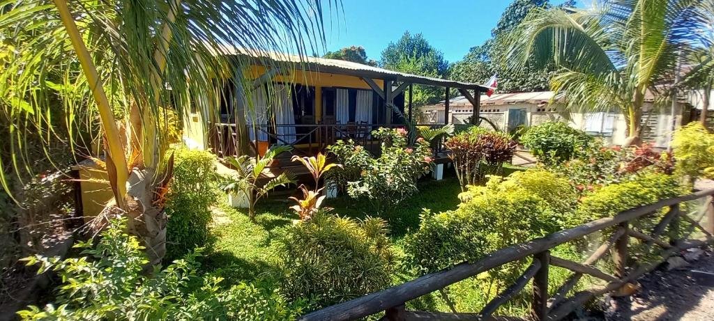 a house with a fence in a garden at Maison Angèle in Nosy Be