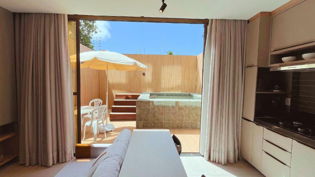 a living room with a couch and an umbrella at Flat FM20 Cabo Branco Piscina Privativa - By Almare in João Pessoa