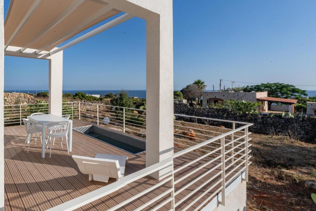 a balcony with a table and a view of the ocean at Il Cubo by LoveSud in Castrignano del Capo