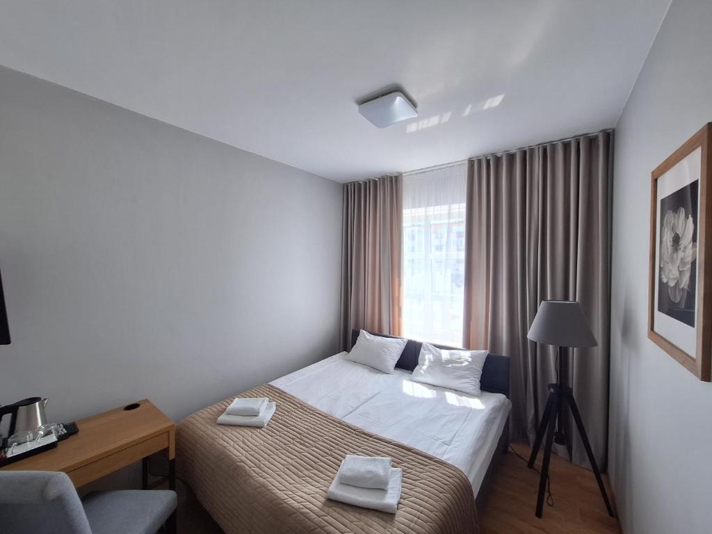 a hotel room with a bed and a window at Kamieniczka in Nidzica