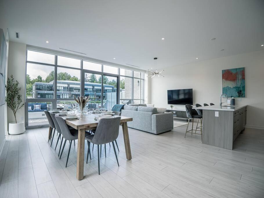 a dining room and living room with a table and chairs at Casa Lago 5 Bed Waterfront House in Innisfil