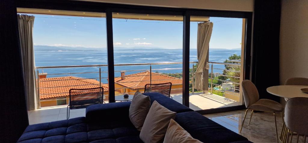 een woonkamer met een bank en een groot raam bij Apartment Eclipse in Opatija