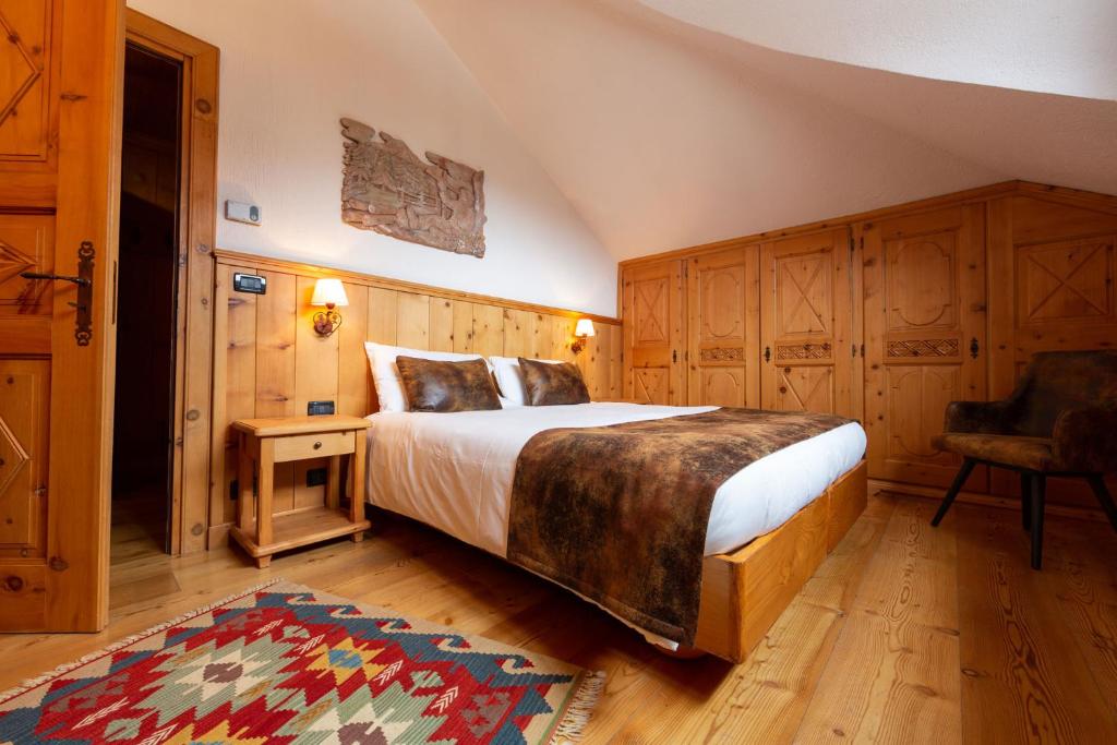 a bedroom with a bed and a chair in it at Hotel Bouton d'Or - Courmayeur in Courmayeur