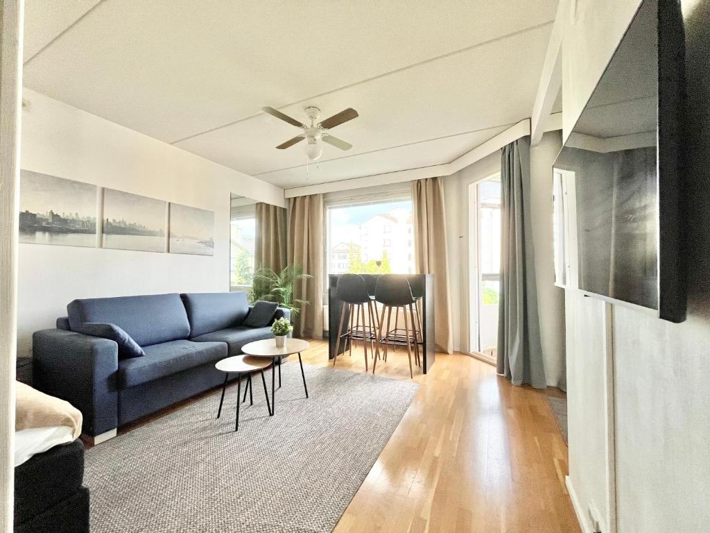 a living room with a blue couch and a table at EP City Suite - Sauna, Balcony & Free parking in Tampere