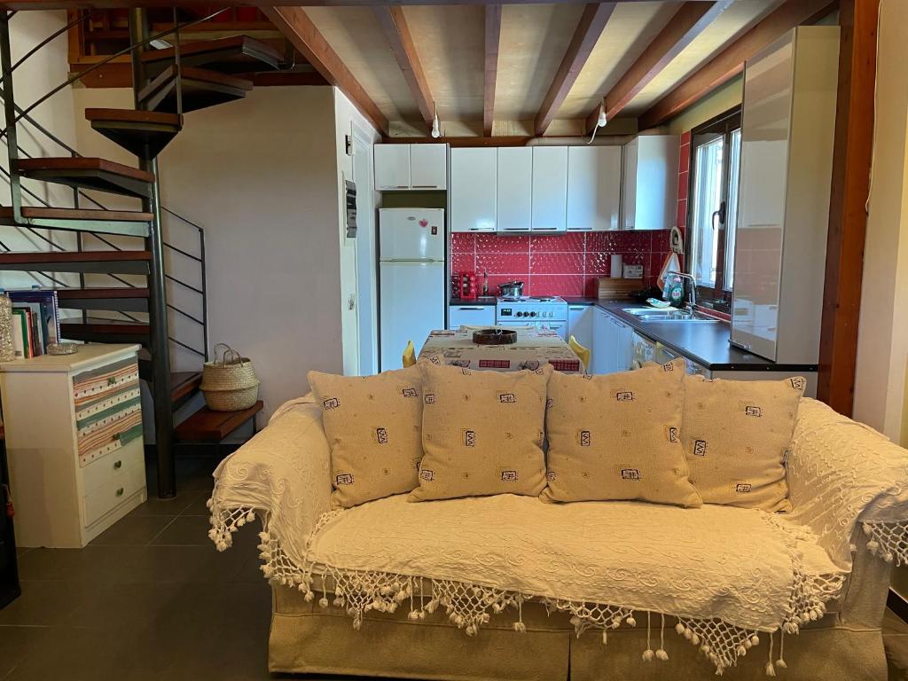 a living room with a couch and a kitchen at Jane's Beautiful Cottage, Eretria in Eretria