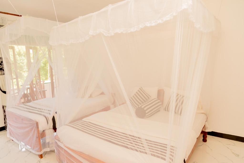 Postel nebo postele na pokoji v ubytování Samiru Guest Inn Ella