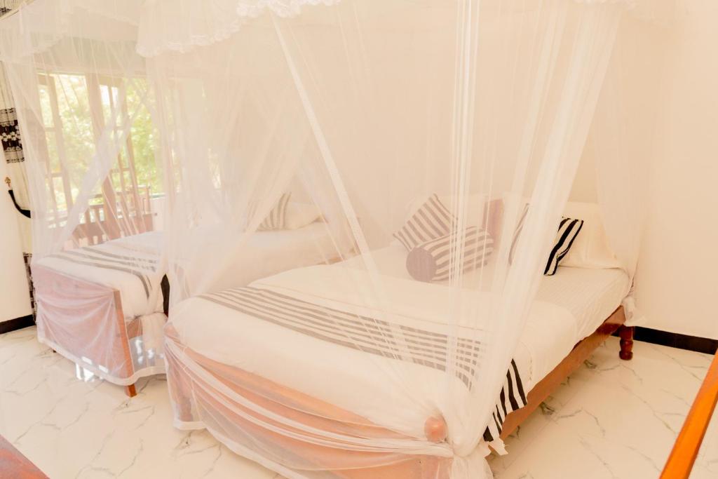 Postel nebo postele na pokoji v ubytování Samiru Guest Inn Ella