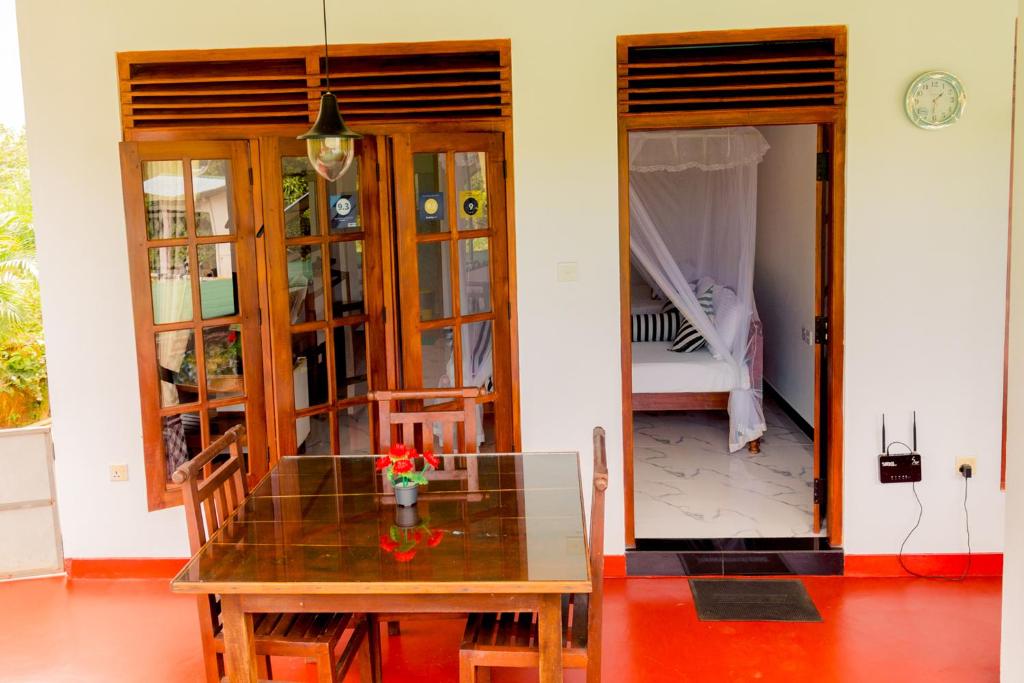 a dining room with a table and a bedroom at Samiru Guest Inn Ella in Ella