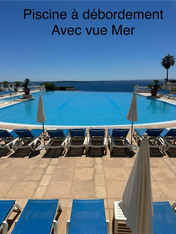 une piscine avec chaises longues et parasols dans l'établissement Villa Francia Résidence piscine tennis à 500m des plages de Cannes, à Cannes