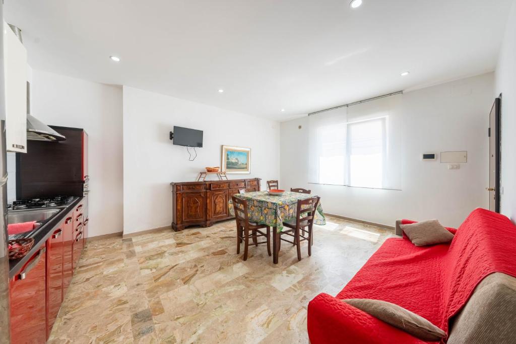 a living room with a table and a kitchen at Residence Anna - Red Apartment in Roseto degli Abruzzi