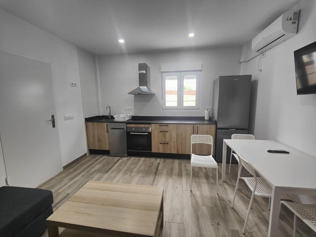 a kitchen with a table and a stove top oven at Apartamentos Bolonia - M a n u e l a in Bolonia