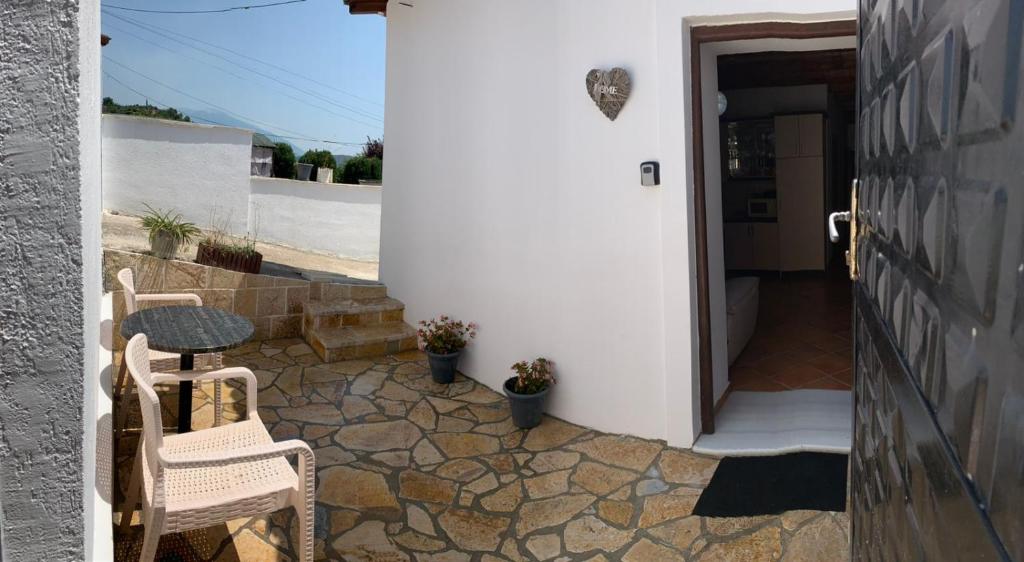patio z 2 krzesłami i stołem obok drzwi w obiekcie NoMad House-entire house at your disposal,4 guests w mieście Berat