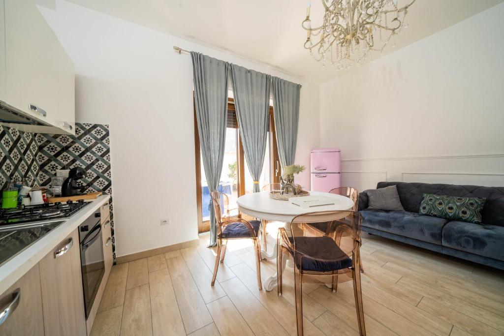 una cucina e un soggiorno con un tavolo e un divano di Vesuvius Apartament a Scafati