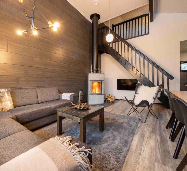 a living room with a couch and a fireplace at Rukanmetsä, cottage, Ruka in Rukatunturi 