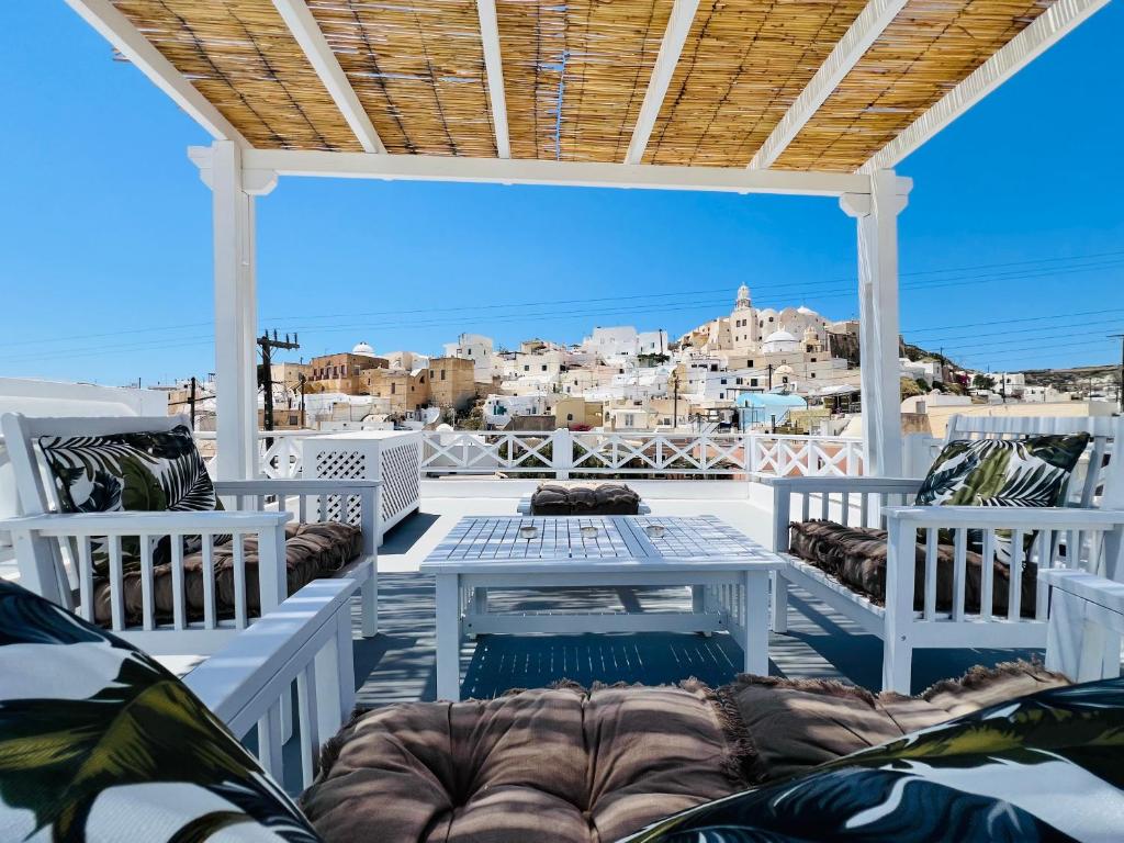 weranda z krzesłami i stołem oraz widokiem na miasto w obiekcie Traditional Cave Villa-Paradise & Prive Jacuzzi w mieście Emporio