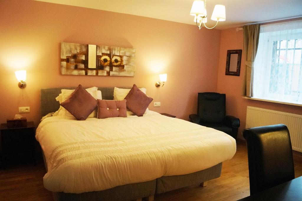 Un dormitorio con una cama grande con almohadas. en EU Guesthouse, en Bruselas
