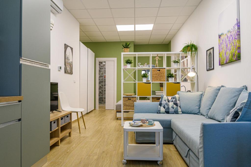 a living room with a blue couch and a table at Open Space Romagna 14 in San Benedetto del Tronto