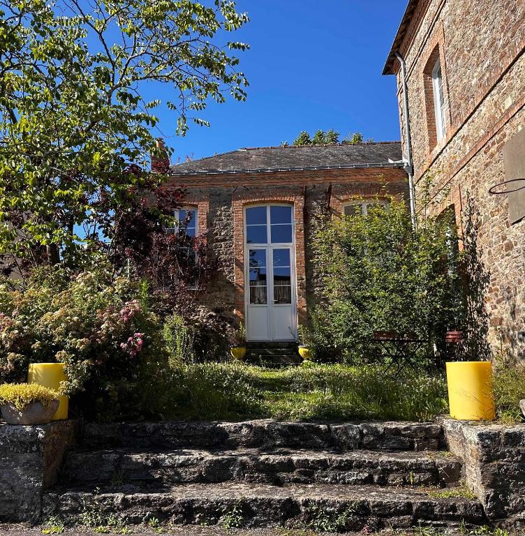 une vieille maison en briques avec une porte blanche dans l'établissement Cottage dans ancienne école de 1850 - 2 à 4 personnes, à Missillac