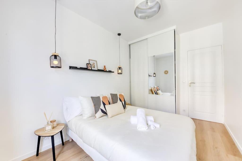 un salon blanc avec un canapé blanc et une table dans l'établissement T2 parisien- 1 min à pied du Métro Ligne 13 & 14, à Paris