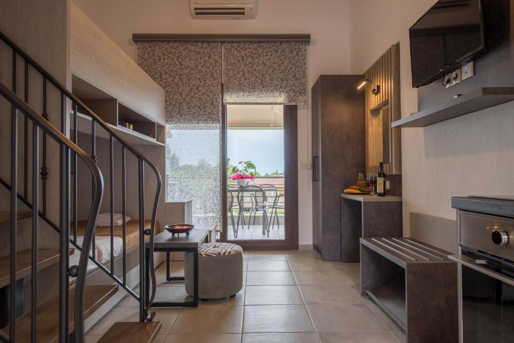 a small kitchen with a view of a balcony at Chasapis Luxury Apartments&Studios in Vourvourou