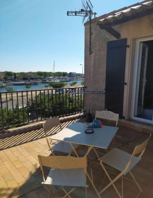 un patio avec une table et des chaises sur un balcon dans l'établissement Appartement à partager entre amis ou familles, à Marseillan
