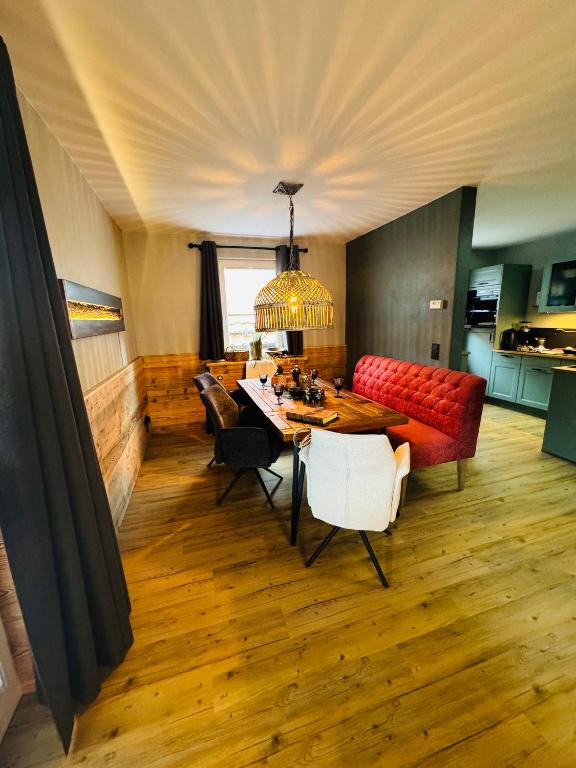 a living room with a table and a red couch at Ferienwohnung HarzReise in Braunlage