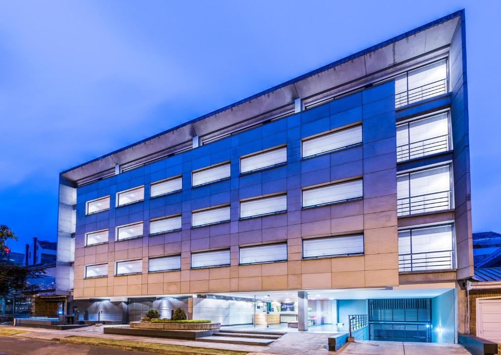 ein Bürogebäude mit blauen Fenstern in der Unterkunft Travelers Obelisco Apartamentos in Bogotá