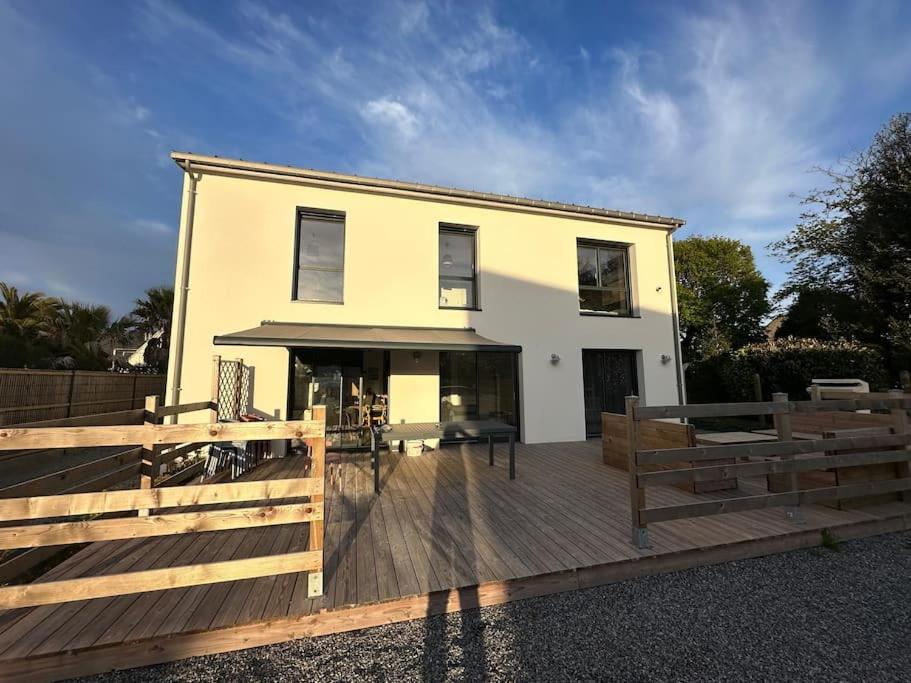 une maison avec une terrasse en bois devant elle dans l'établissement Lokentaz- Maison Familiale, à Saint-Gildas-de-Rhuys