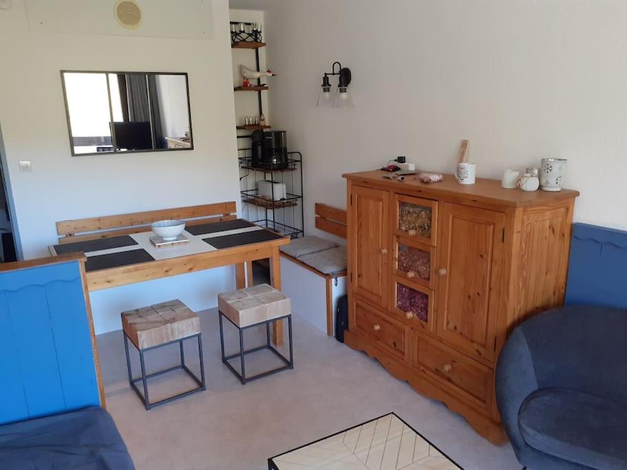 - un salon avec un bureau et un canapé bleu dans l'établissement Studio cabine Pégase 18 08 étage élevé balcon sud vue pistes, à Villarembert