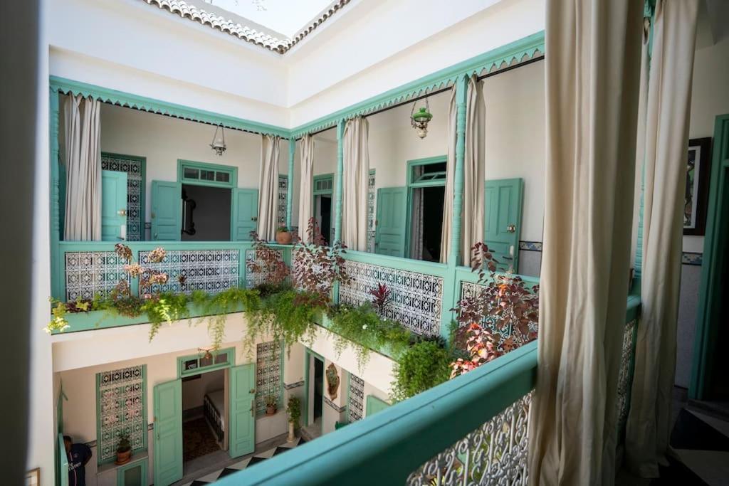 a balcony of a building with plants on the windows at Charming Medina Riad 8 rooms with pool - Riad INN Medina in Marrakech
