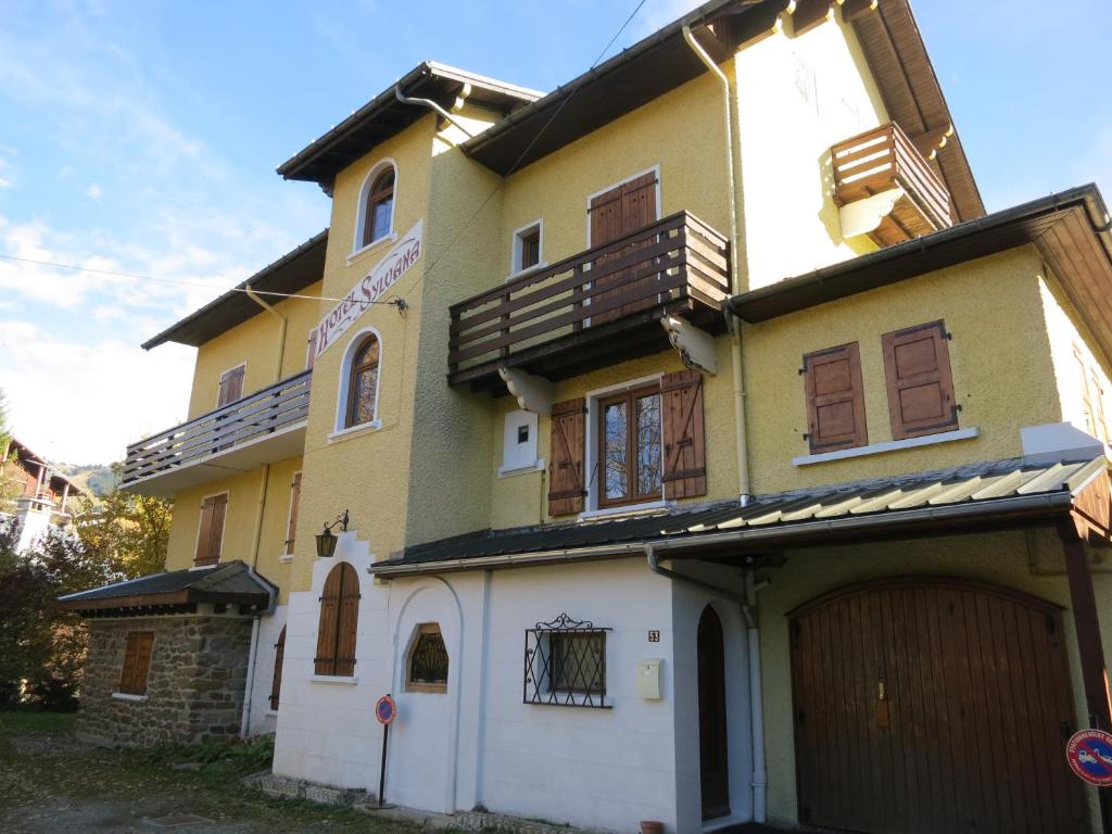 een geel en wit huis met een garage bij Hotel Sylvana in Megève