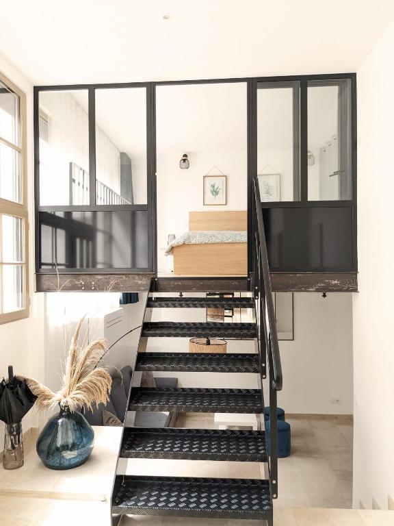 un escalier avec des marches noires dans une chambre avec un lit dans l'établissement Le loft Rousseau, à Dijon