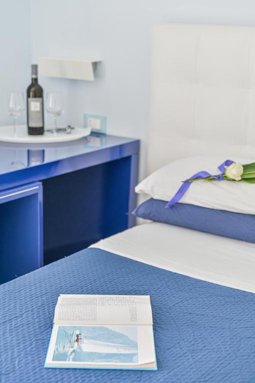 a bottle of wine sitting on top of a bed at LINUS by BREATHE LIGURIA in La Spezia
