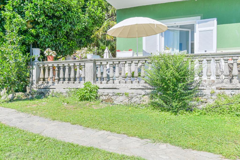 a white fence with an umbrella in front of a house at LINUS by BREATHE LIGURIA in La Spezia
