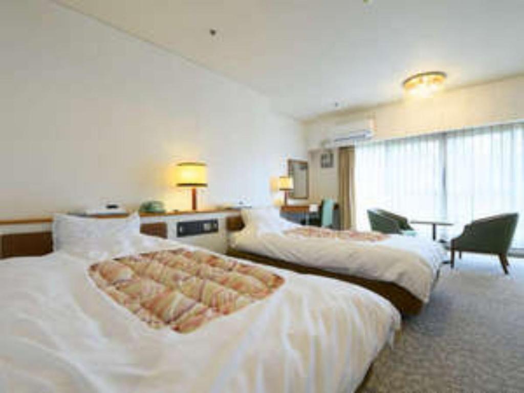 une chambre d'hôtel avec deux lits et un bureau dans l'établissement Hotel Tetra Resort Shizuoka Yaizu - Vacation STAY 35233v, à Yaizu