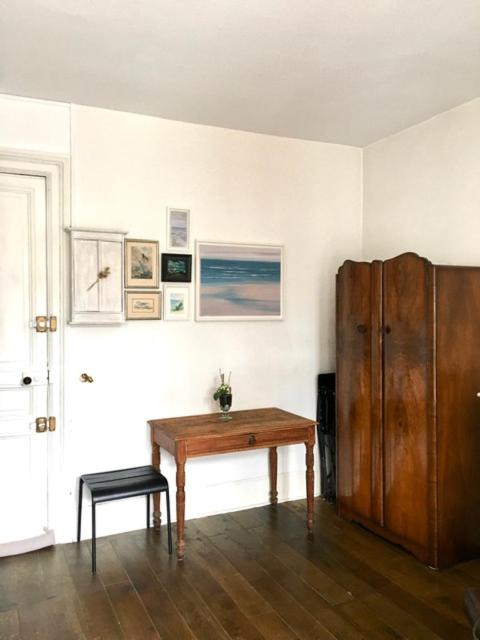 Cette chambre dispose d'une table et d'une armoire en bois. dans l'établissement grand studio en plein centre de Trouville, à Trouville-sur-Mer