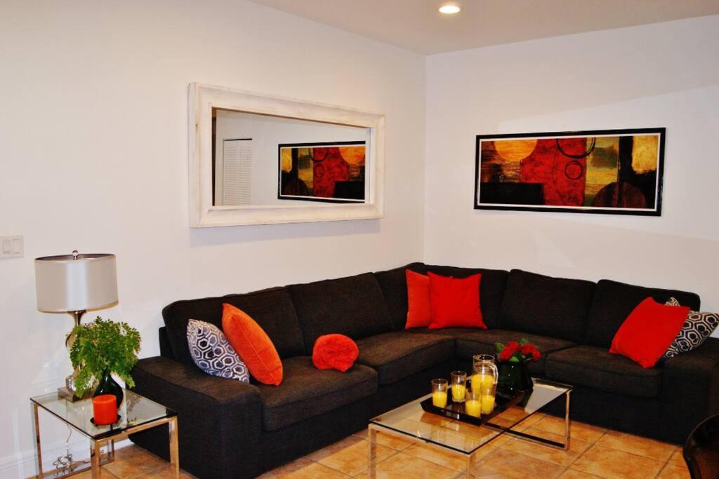 - un salon avec un canapé noir et des oreillers rouges dans l'établissement Tranquil 2 bed 1 bath at Beach, Glimpse of the Ocean, à Miami Beach