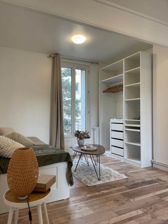 un salon avec un lit et une table dans l'établissement Cosy Studio - near Paris, à Boulogne-Billancourt